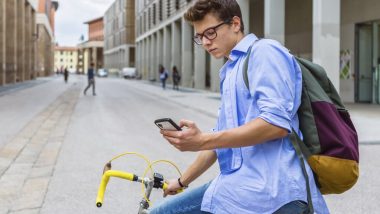 young-man-checks-phone-bicycle-1.jpg